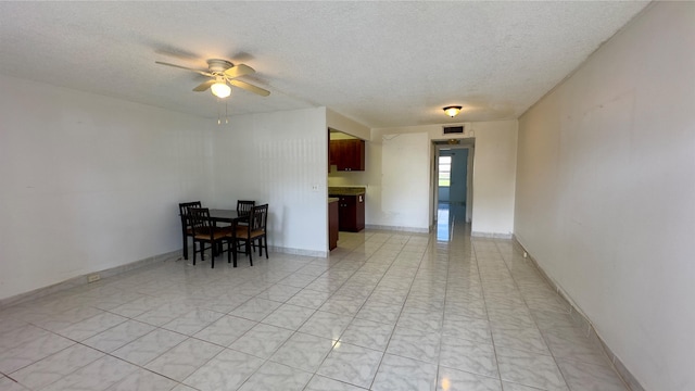 interior space with ceiling fan and a textured ceiling