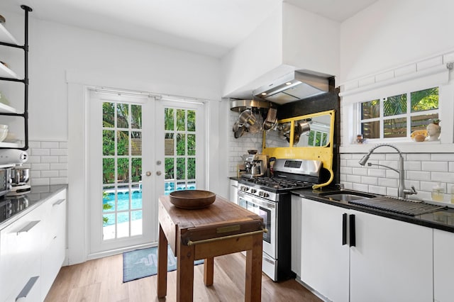 kitchen with white cabinetry, light wood-type flooring, sink, and stainless steel gas stove