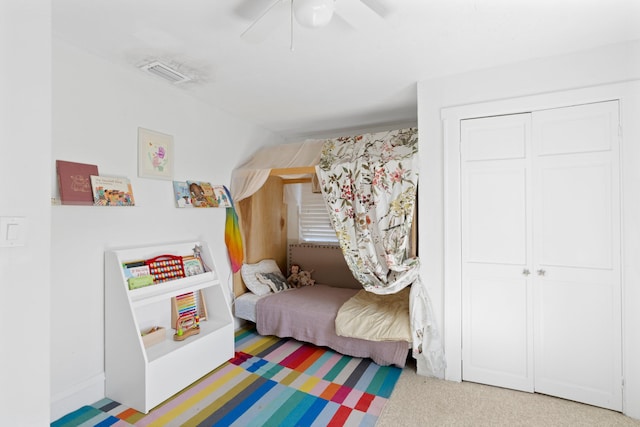 bedroom with ceiling fan, carpet floors, and a closet