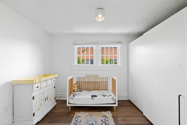 bedroom with dark hardwood / wood-style floors