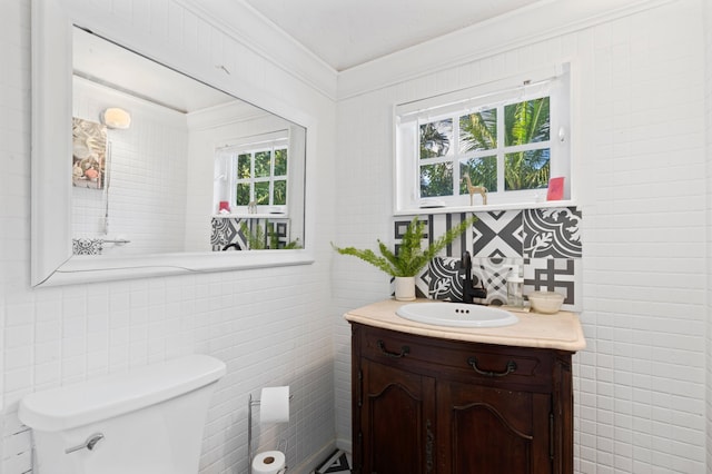 bathroom featuring tile walls, vanity, crown molding, and toilet