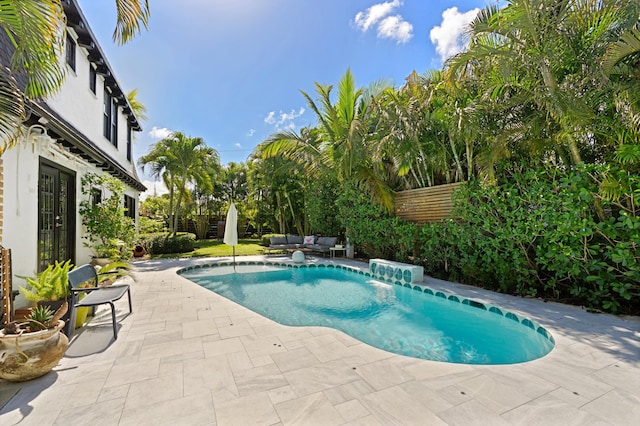 view of swimming pool with an outdoor living space, a patio, and pool water feature