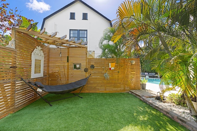 view of yard featuring a fenced in pool and a pergola