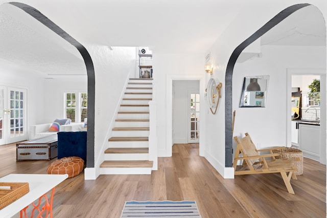 entrance foyer with french doors and light hardwood / wood-style flooring