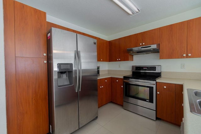 kitchen with light tile patterned flooring, appliances with stainless steel finishes, and sink