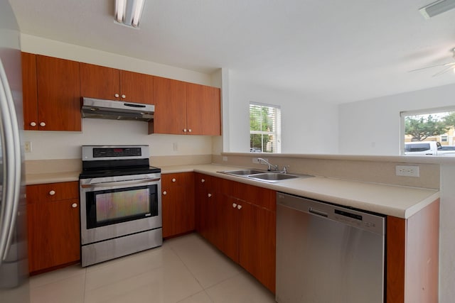 kitchen featuring sink, light tile patterned floors, ceiling fan, kitchen peninsula, and stainless steel appliances