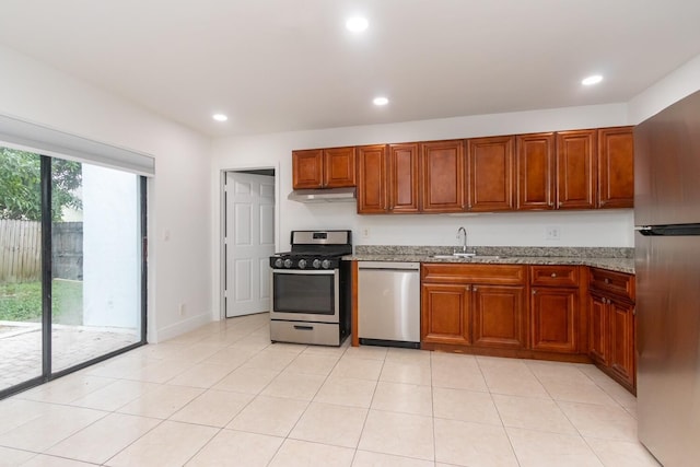 kitchen featuring appliances with stainless steel finishes, light stone countertops, sink, and light tile patterned floors