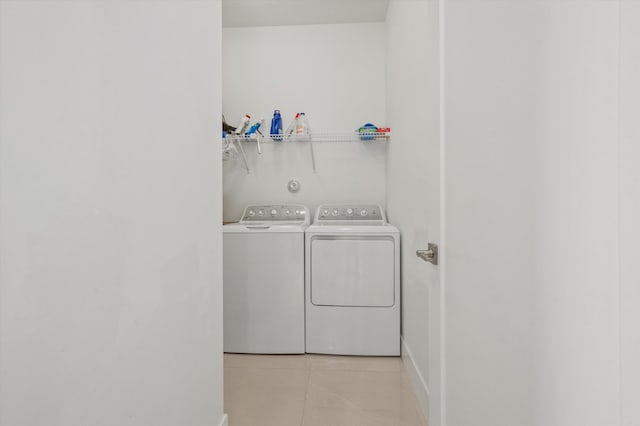 laundry area with washer and dryer and light tile patterned floors