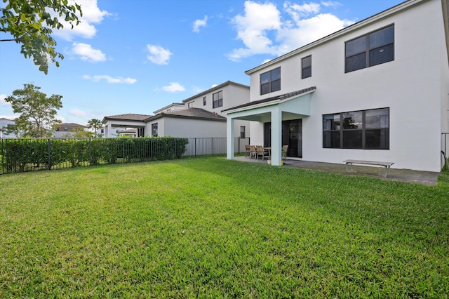 rear view of property featuring a yard and a patio