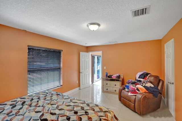 bedroom featuring a textured ceiling and light tile patterned floors