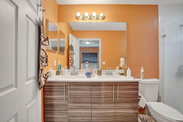 bathroom featuring vanity, a shower with shower door, and toilet