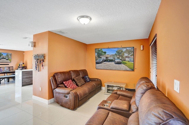 living room with light tile patterned flooring and a textured ceiling