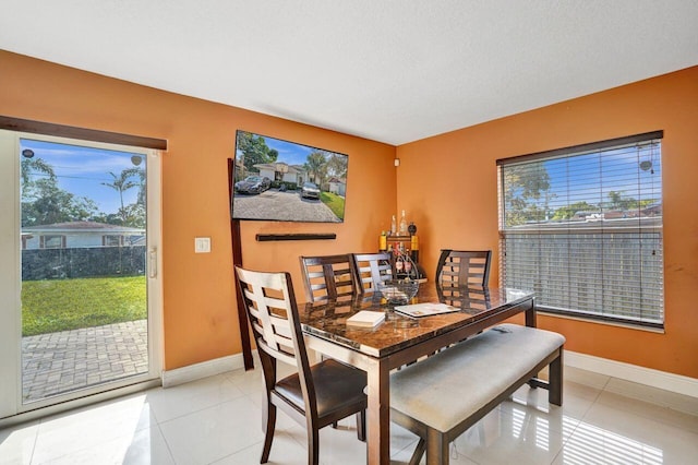 tiled dining area with a textured ceiling