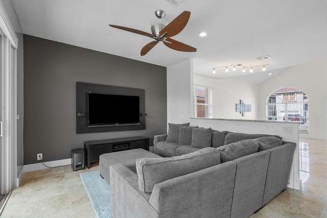 living room featuring ceiling fan, plenty of natural light, and vaulted ceiling