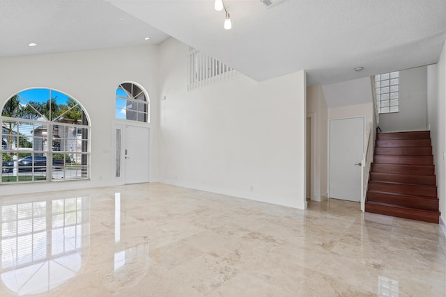 spare room with a high ceiling and a textured ceiling