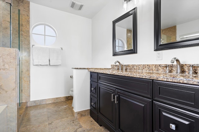 bathroom with vanity, toilet, and tiled shower