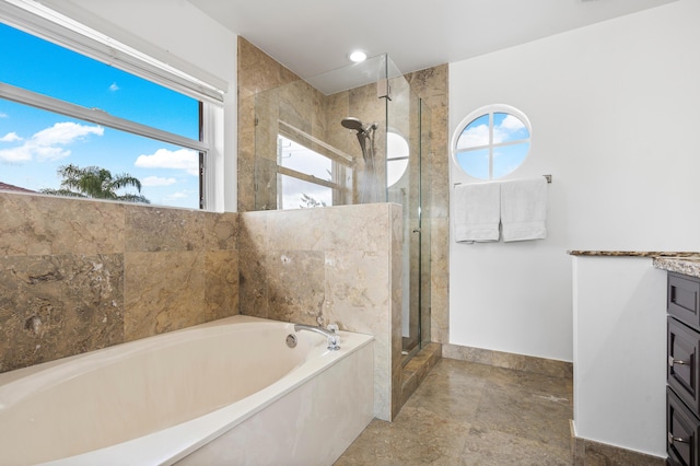 bathroom featuring vanity and independent shower and bath