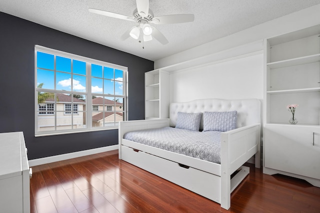 bedroom featuring ceiling fan, dark hardwood / wood-style floors, and a textured ceiling