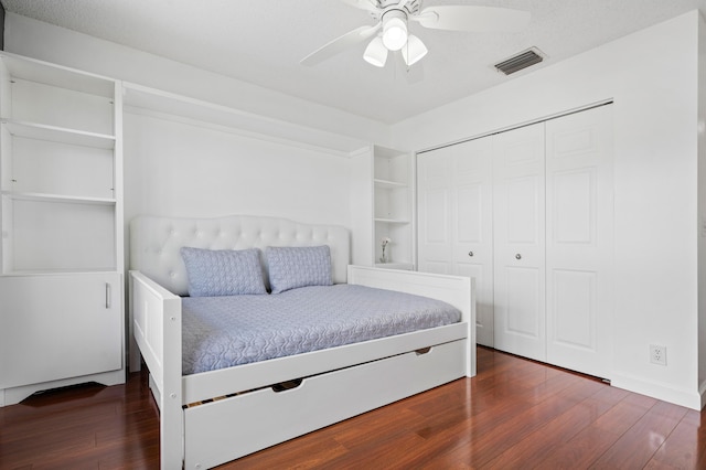 bedroom with ceiling fan, dark hardwood / wood-style flooring, and a closet