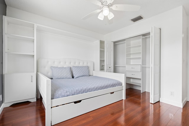 bedroom with ceiling fan, dark hardwood / wood-style floors, and a closet