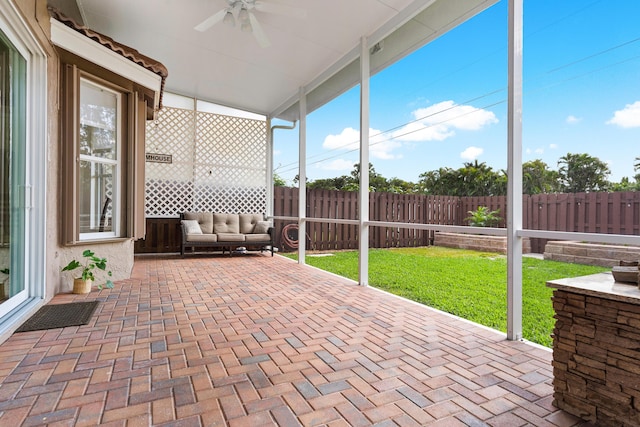 unfurnished sunroom with ceiling fan