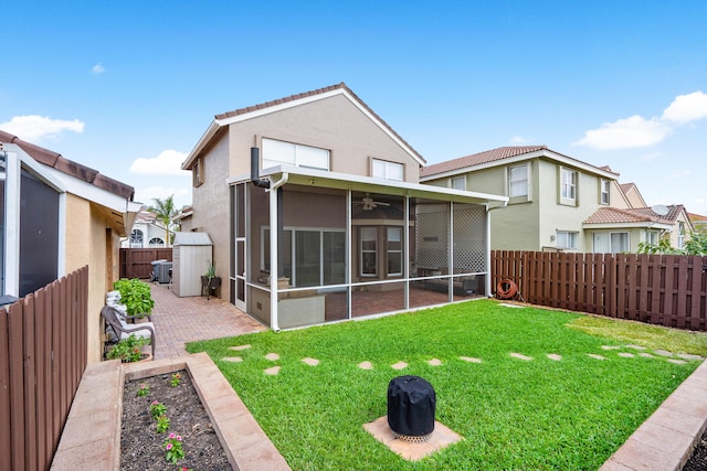 rear view of property featuring a patio, a sunroom, and a lawn