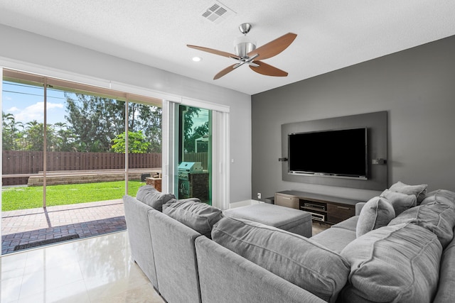 tiled living room with a textured ceiling and ceiling fan