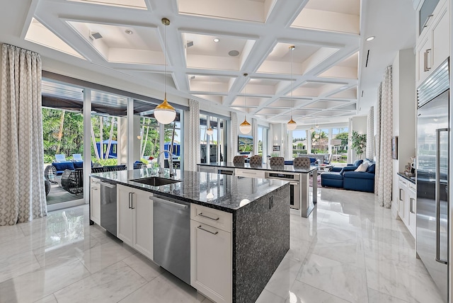 kitchen with a spacious island, open floor plan, appliances with stainless steel finishes, marble finish floor, and a sink