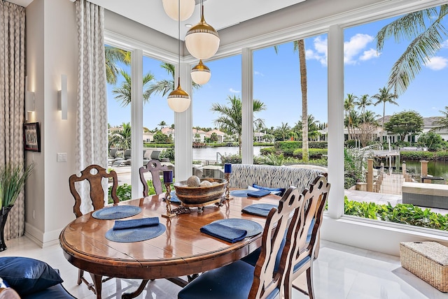 sunroom / solarium with a water view and a healthy amount of sunlight