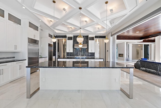 177 Commodore Dr, Jupiter, FL 33477 - kitchen with built in refrigerator, tasteful backsplash, coffered ceiling, a spacious island, and glass insert cabinets