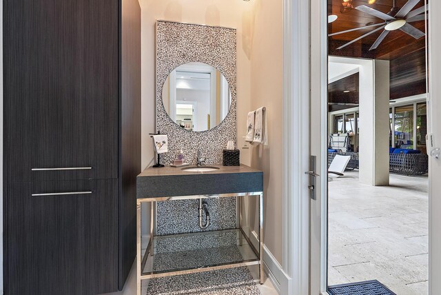 interior space featuring decorative backsplash, ceiling fan, and a sink