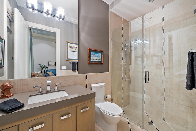 full bathroom featuring vanity, toilet, tile walls, and a shower stall