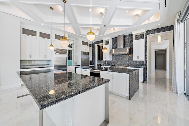 177 Commodore Dr, Jupiter, FL 33477 - kitchen featuring a spacious island, built in fridge, wall chimney exhaust hood, decorative backsplash, and coffered ceiling