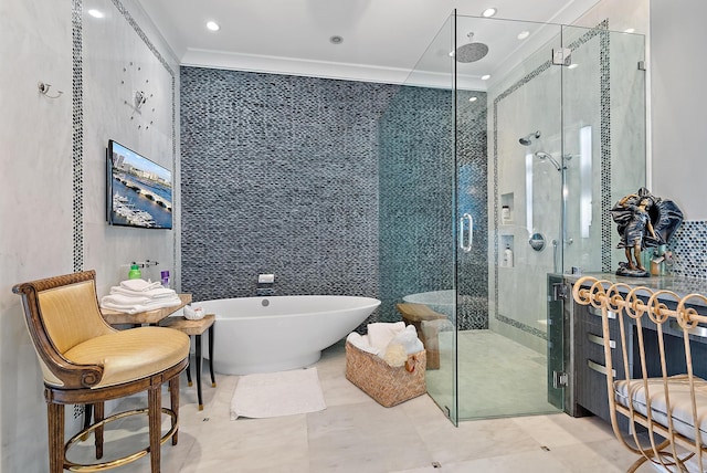 bathroom featuring a freestanding bath, tile walls, ornamental molding, and a shower stall