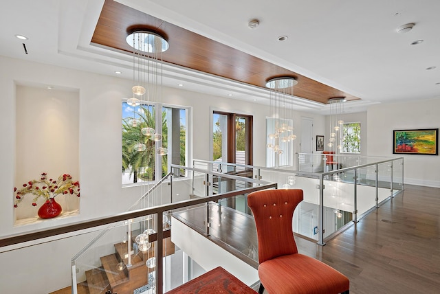 staircase featuring recessed lighting, baseboards, a tray ceiling, and wood finished floors