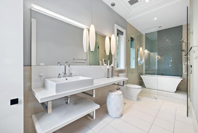 full bathroom with baseboards, double vanity, ornamental molding, a sink, and a shower stall