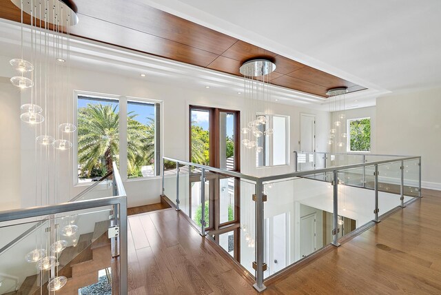 177 Commodore Dr, Jupiter, FL 33477 - hallway featuring an upstairs landing, wood finished floors, baseboards, and a raised ceiling
