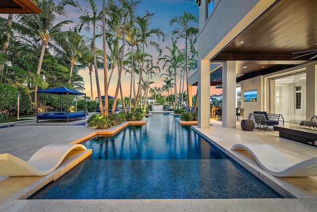 177 Commodore Dr, Jupiter, FL 33477 - pool at dusk featuring an outdoor pool and a patio area