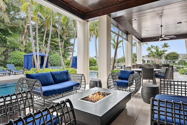 view of patio / terrace with an outdoor living space with a fire pit, outdoor dining area, an outdoor pool, and ceiling fan