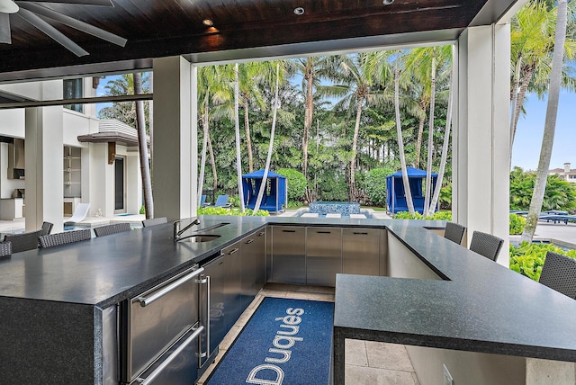 view of patio with outdoor dining space, an outdoor kitchen, and a sink