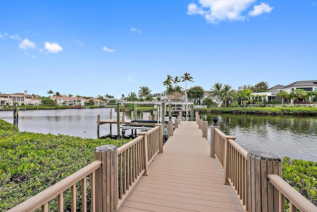 dock area featuring boat lift, a residential view, and a water view