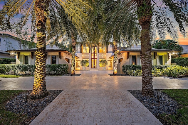 view of front of house with decorative driveway and stucco siding