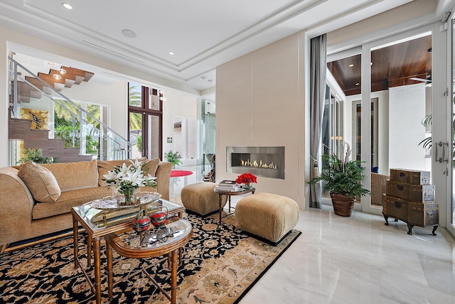 living area featuring recessed lighting, stairway, marble finish floor, and a glass covered fireplace