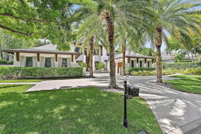 177 Commodore Dr, Jupiter, FL 33477 - view of front facade with curved driveway, a front lawn, and stucco siding