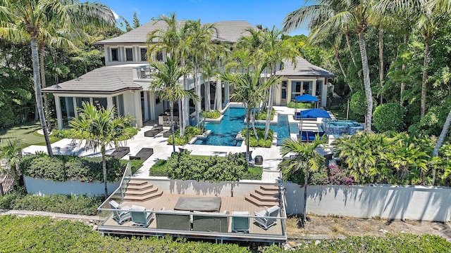 177 Commodore Dr, Jupiter, FL 33477 - back of property with a patio, a tile roof, and an outdoor pool
