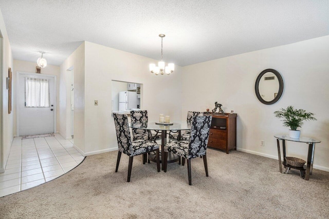 carpeted dining area featuring a textured ceiling and a notable chandelier