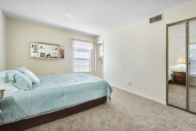 bedroom featuring carpet floors, a closet, and a textured ceiling