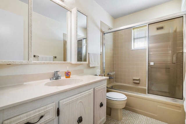 full bathroom with toilet, vanity, shower / bath combination with glass door, and tile patterned flooring