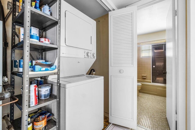 laundry area featuring tile patterned flooring and stacked washer and dryer