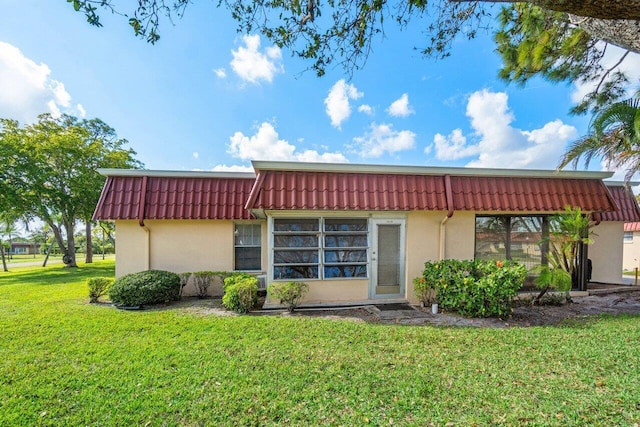 rear view of property with a lawn